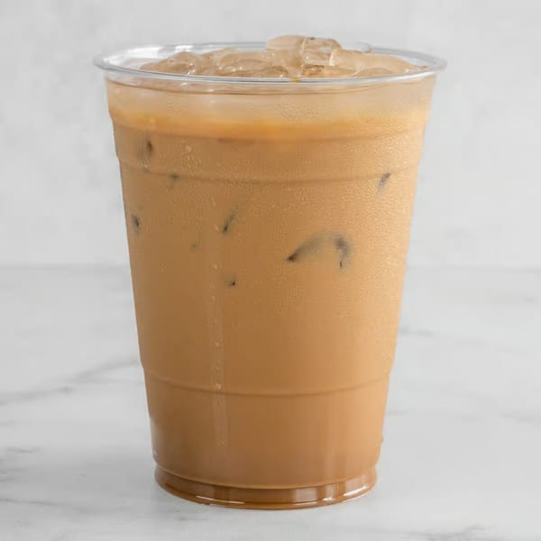 Iced Vietnamese coffee in a clear plastic cup with ice, condensation on the outside.